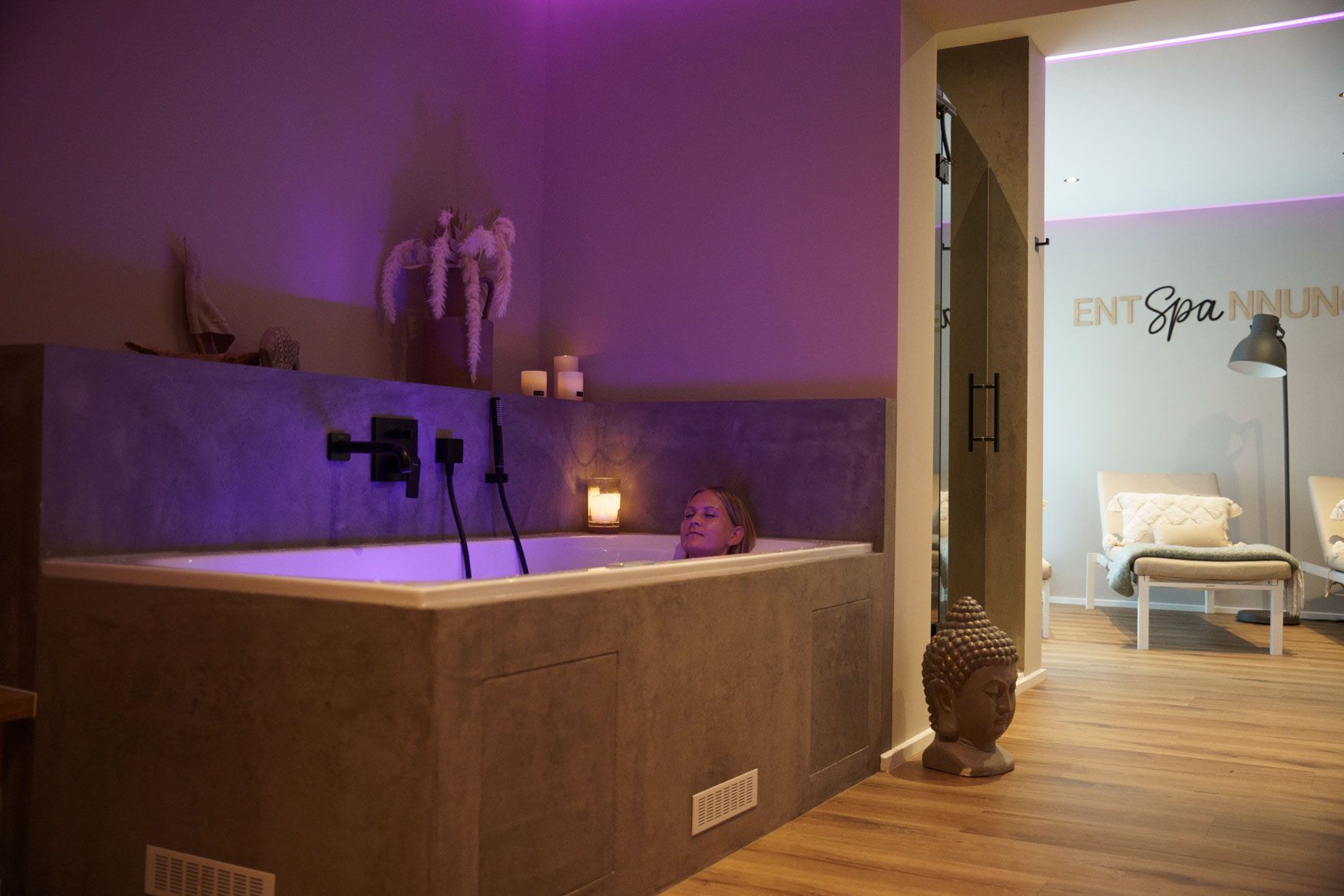 Junge Frau entspannt in einer Whirlpool-Badewanne im Spabereich des Ferienhofs