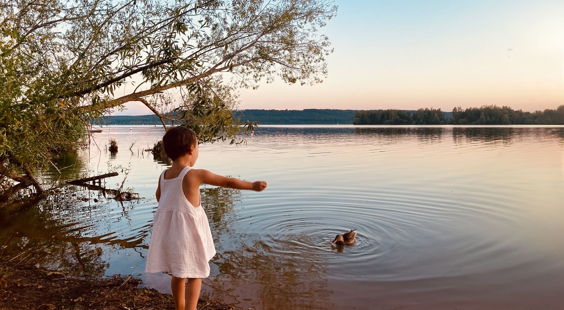 Kind blickt auf den Brombachsee in der Abenddämmerung