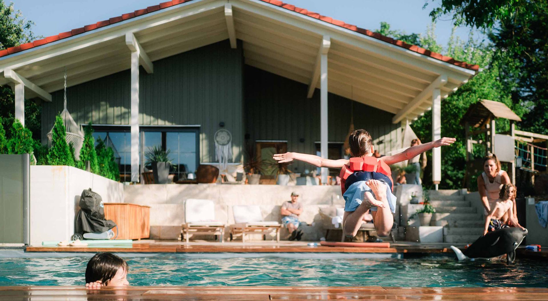 A child jumps into the natural pool at the Eichenberg holiday farm