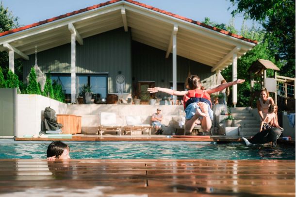 Naturpool im Sommer mit spielenden Kindern